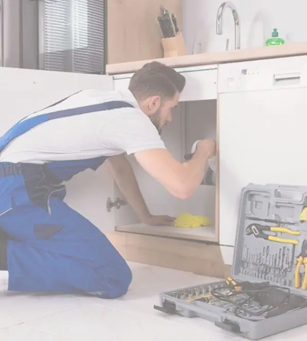 Fontanero arreglando el grifo de una cocina